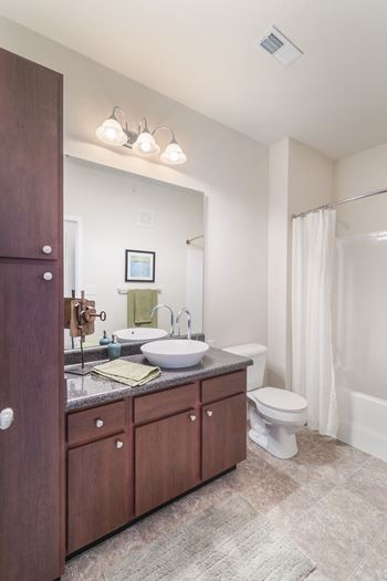 A bathroom with a sink, toilet, and a shower curtain.